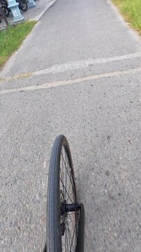First Person View of Bicycle Wheel on Asphalt