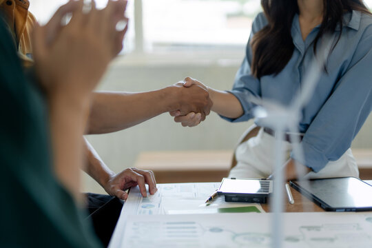 Business professionals shaking hands, sealing sustainable energy partnership
