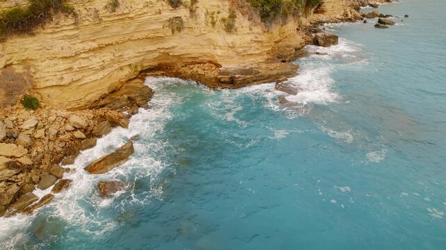 Waves wash against limestone cliffs along Kefalonia rugged shoreline in summer