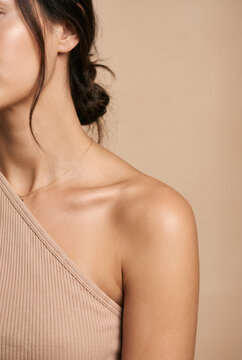 Woman touching neck in close-up sensual portrait with hair bun