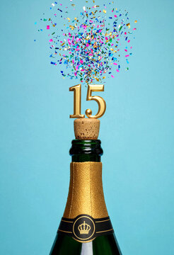 Celebratory champagne bottle popping with gold fifteen number and colorful confetti explosion party scene
