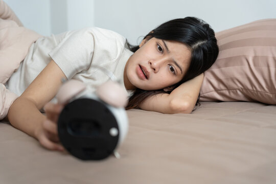 Shocked Asia young woman looking at clock alarm, lady is late appointment or work or class study, overslept, difficulty get up in mornings, time worried, not on time, sleepy, over due, Hurry up time