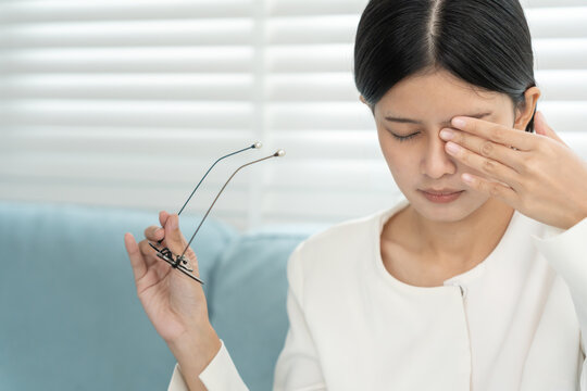 Eye problems, Asian women with tired and irritated eyes, eye rubbing, dry, eye pain after work, migraine, headache, blurred vision, photophobia, eye hurt from Read a book for a long time.