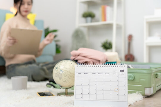 Travel bag. female are checking the detail and quantity of items used during the trip by checklist. Young women are prepare clothes and personal belongings. Pack your luggage before travel.