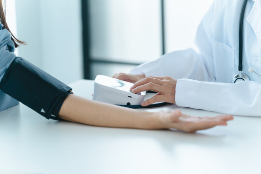 doctor measures a patient blood pressure in a consultation room