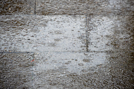Heavy rain falling on paved area for use as a background texture
