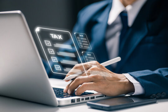 Business professional using laptop with virtual tax documents, representing online tax filing, financial accounting, digital paperwork, compliance, payment and electronic finance management.