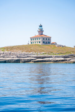 Porer Lighthouse on Porer Islet near Cape Kamenjak in Istria Croatia on the Adriatic Sea. Historic lighthouse guiding maritime navigation along the rocky coast.