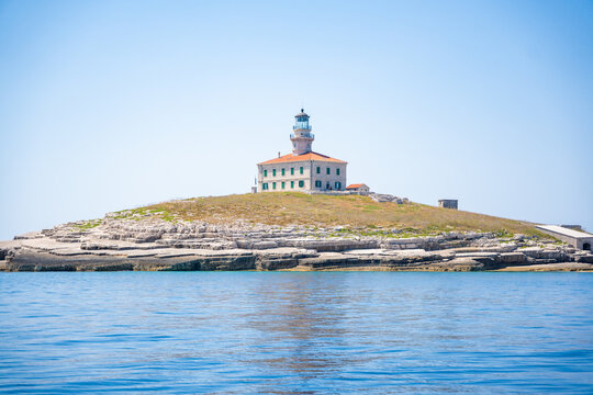 Porer Lighthouse on Porer Islet near Cape Kamenjak in Istria Croatia on the Adriatic Sea. Historic lighthouse guiding maritime navigation along the rocky coast.