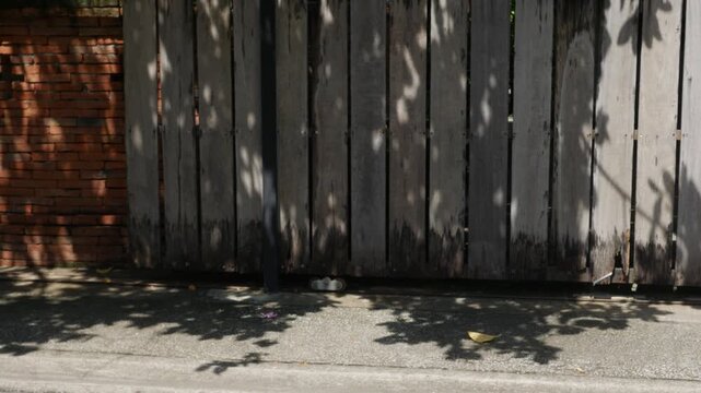 Warm-Toned Wooden Slat Fence with Dappled Tree Shadow Pattern in Sunlight