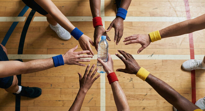 Team circle supporting each other with water on court