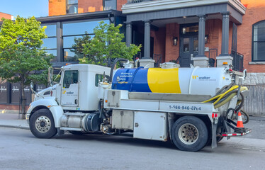 Fototapeta premium Ottawa, ON, Canada. Aug 19, 2026. Side profile of a Walker Grease Trap Services tank truck parked on an urban street in front of a building.