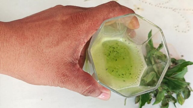Stirring Green Basil and Lemon Juice Infused with Turpentine Drops