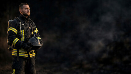 Fototapeta premium Professional Firefighter in Protective Gear Standing in Smoke After Fire