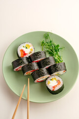 Fresh sushi maki rolls served on green plate © Cavan