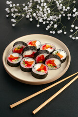 Fresh sushi maki rolls on a plate with chopsticks © Cavan