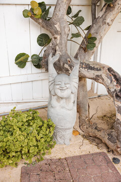 Joyful laughing Buddha statue in a sandy garden