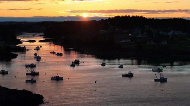 Fishing boats anchored in a calm harbor at sunrise, Cutler, Maine.