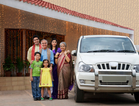 Portrait of a family standing with their car 