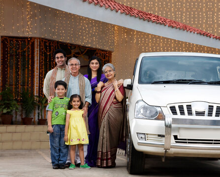 Portrait of a family standing next to a car 