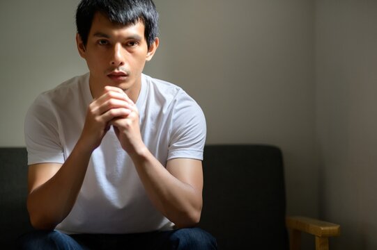 Pensive Young Man Contemplating His Thoughts in Minimalist Setting