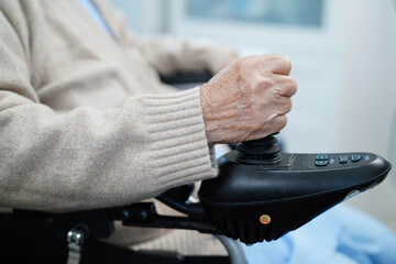 Asian elderly disability woman patient use joystick electric wheelchair in hospital. © manassanant