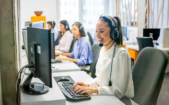 Smiling customer service representative typing on computer in office