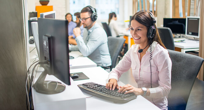 Happy young woman working as a customer service representative in office