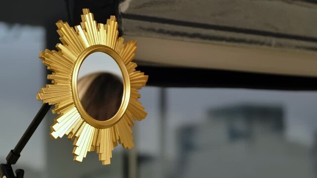 Golden sunburst mirror reflecting urban cityscape, decor and luxury concept