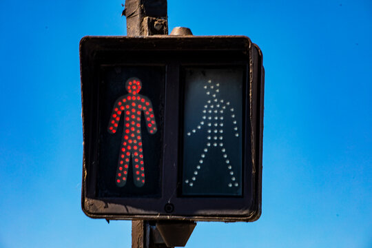 A pedestrian traffic light with a red man on, indicating a ban on crossing the street. Traffic rules for pedestrians.