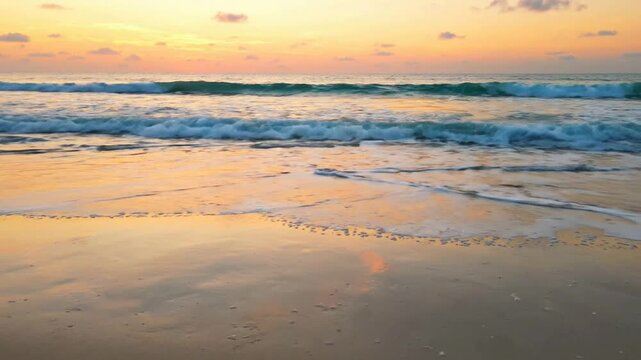 Golden hour beach sunset with gentle ocean waves rolling onto sandy shoreline at dusk