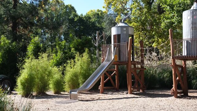 Agricultural-themed children's playground in Kyneton Victoria, Australia, featuring a slide integrated into a grain silo structure alongside a tractor. Regional Australian park design, play equipment