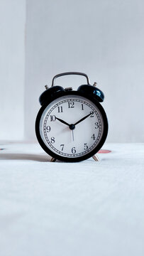 Black Alarm Clock on White Minimal Background, Time Concept