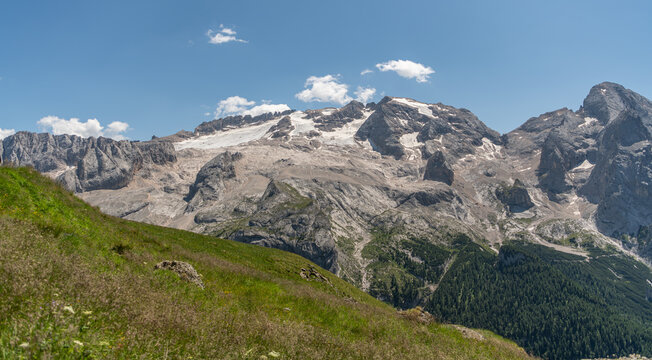 Arabba, Italy. Marmolada glacier and rugged Dolomite mountain massif above alpine meadows