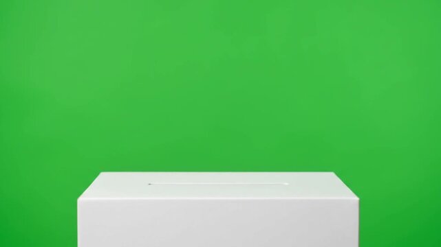 White ballot box with a slot on a vibrant green screen background for voting concepts