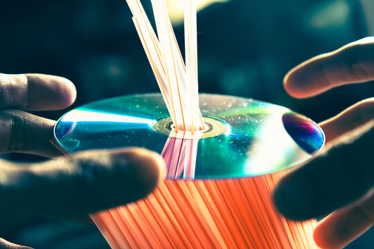 Compact DVD Disc Resting on Plastic Drinking Straws Illustrating Modern Plastic Pollution and Environmental Waste Concept
