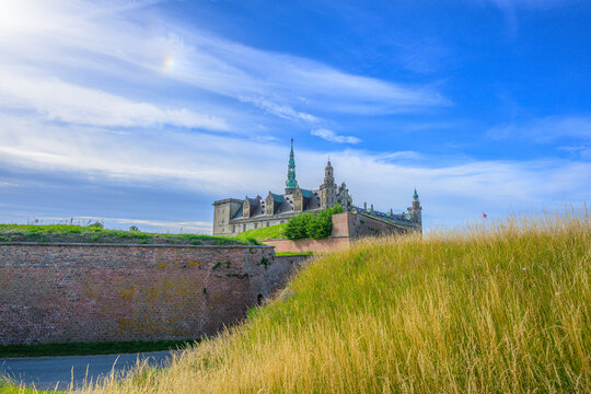 Helsing?r, Denmark - June 30 2026: Kronborg Castle rises beyond grassy ramparts under dramatic summer sky.