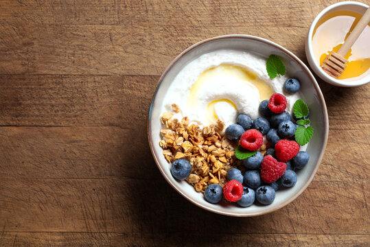 Granola bowl with greek yogurt, berries and honey for healthy breakfast.