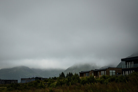 Modern cabins on a foggy mountain hillside