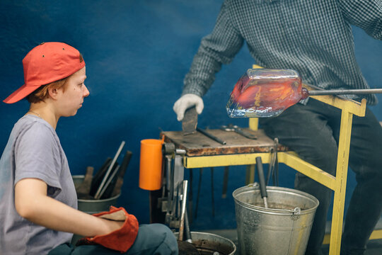Young woman learning the craft of glassblowing