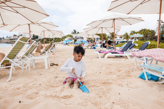 Young boy plays in the sand on a crowded beach