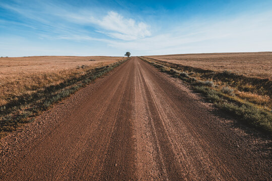 Long straight dirt road disappearing into the horizon, North Dakota