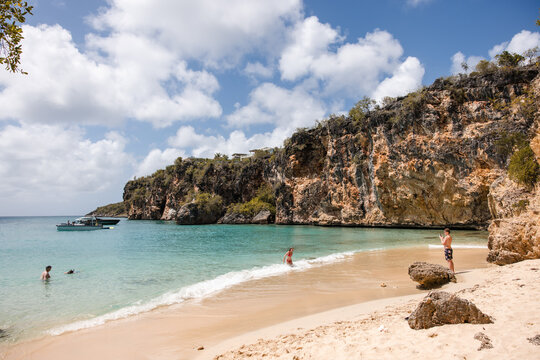 People enjoying a sunny day at a tropical beach cove