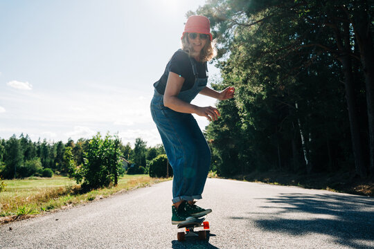 Woman enjoying skateboarding on a country road