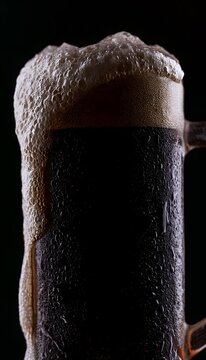 Dark Beer's Frothy Cascade A Refreshing Moment Captured In Dramatic Studio Lighting
