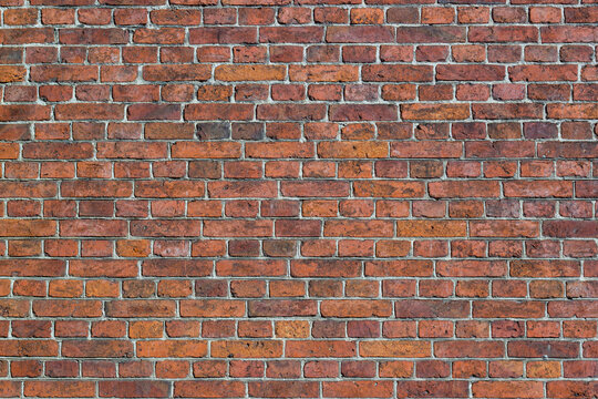 Weathered red brick wall with gray mortar, irregular masonry pattern and rustic textured surface ideal for architectural background