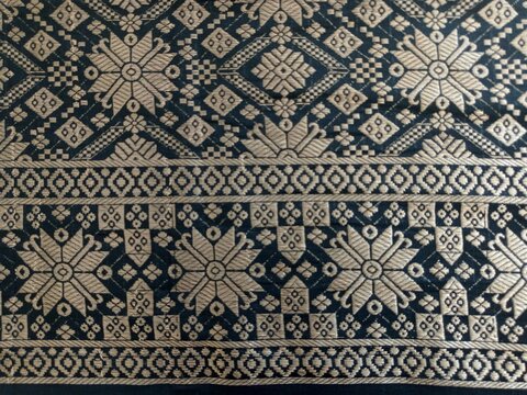 Elegant black songket textile with gold geometric star pattern