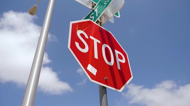 Red Stop Sign At Street Intersection Against Blue Sky