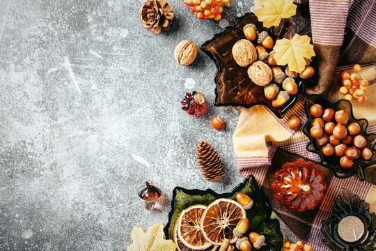 Autumn composition. Side border flat lay with cozy plaid, fall leaves, pumpkins, acorns and nuts.