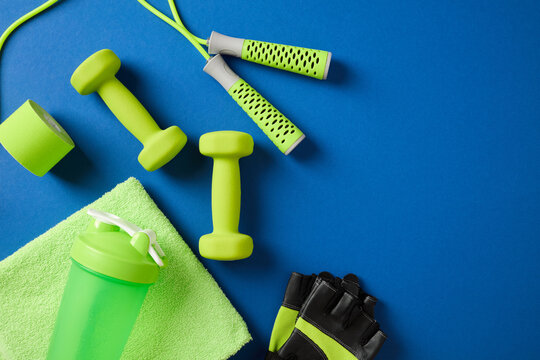 Fitness accessories layout on dark blue background with space.